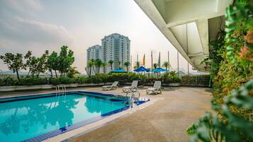 Una piscina al aire libre, tumbonas