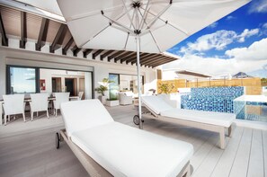 A rooftop terrace with a pool, lounge chairs, and a dining area. - Cap Ouest by Dream Escapes (Flic-en-Flac)