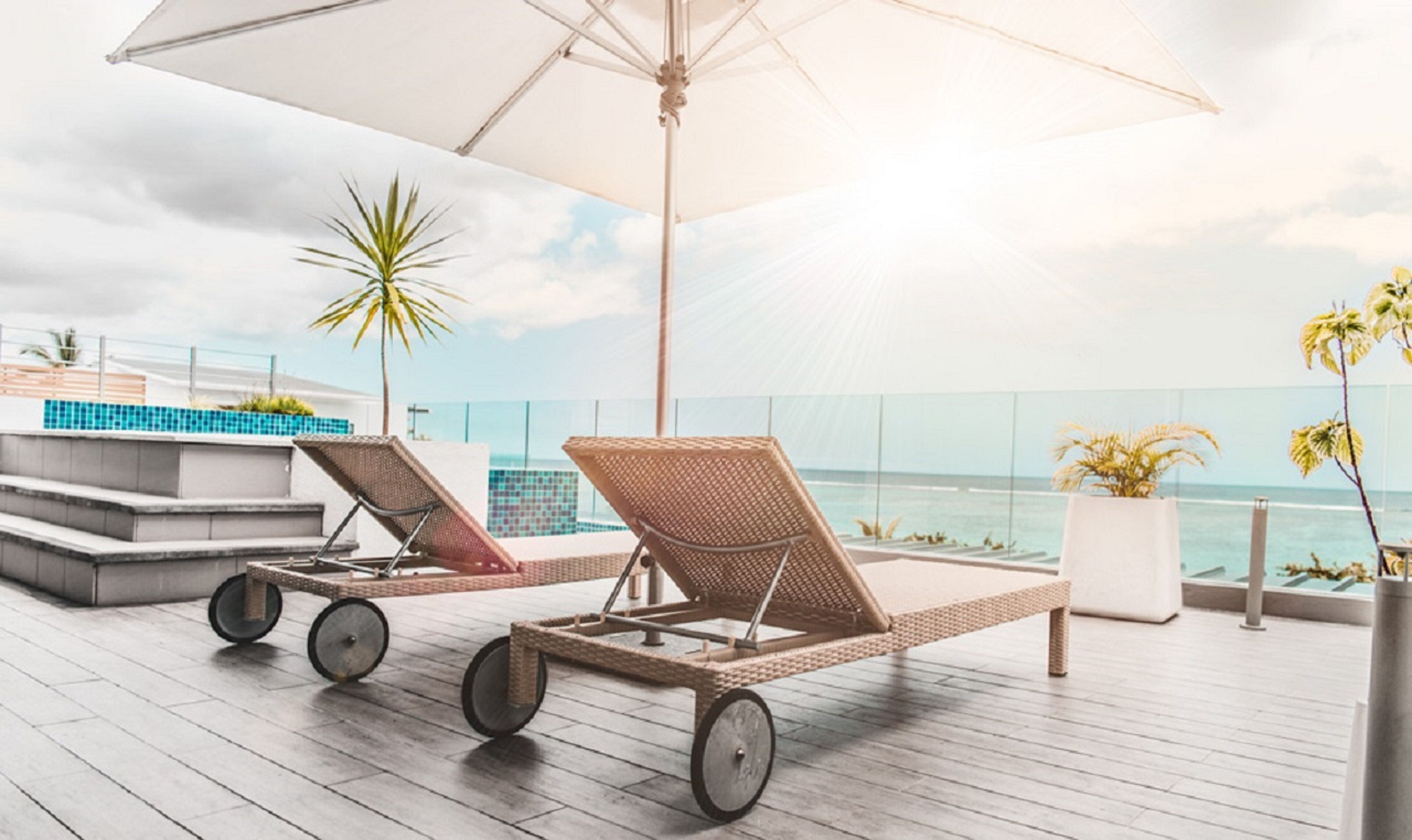 Una piscina al aire libre, sombrillas, sillones reclinables de piscina