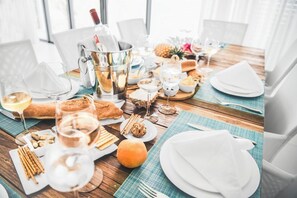 A table set for a meal with various dishes, glasses, and a bottle of champagne. - Cap Ouest by Dream Escapes (Flic-en-Flac)