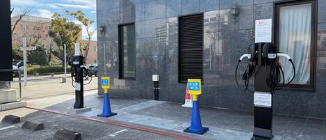 An EV charging station with a modern building in the background.