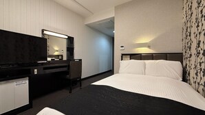 A hotel room with a bed, a desk, a chair, a TV, and a wall-mounted light. - APA Hotel Kagoshima Kokubu (Kirishima)