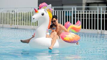 Una persona en un flotador con forma de unicornio en una piscina.