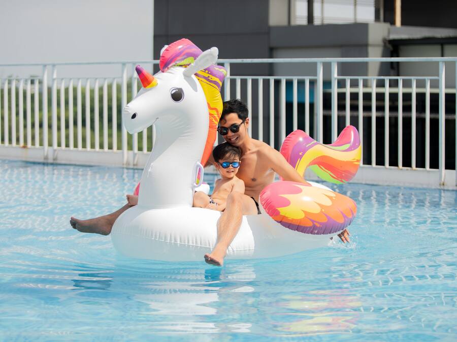 Una persona en un flotador con forma de unicornio en una piscina.