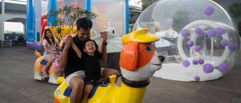Un caballo de juguete para montar con un niño y un adulto.