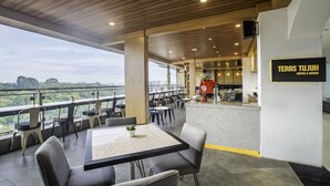 A modern outdoor dining area with a view of the landscape, a bar area, and a sign for 'TERAS TUJUH Coffee & Espresso'. - Grand Tjokro Premier Bandung (Bandung)