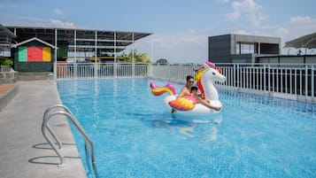 Guests can enjoy a refreshing swim in the pool, surrounded by a secure white fence.