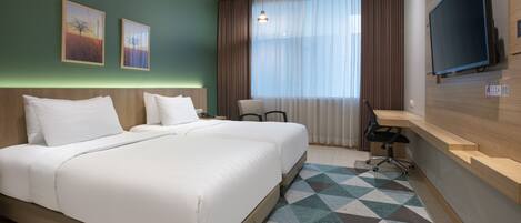 A hotel room with a large bed, a desk, a chair, a TV, and artwork on the wall.
