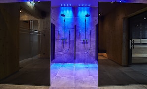 Un pasillo moderno y bien iluminado, con paredes de madera y una puerta de cristal a la izquierda.