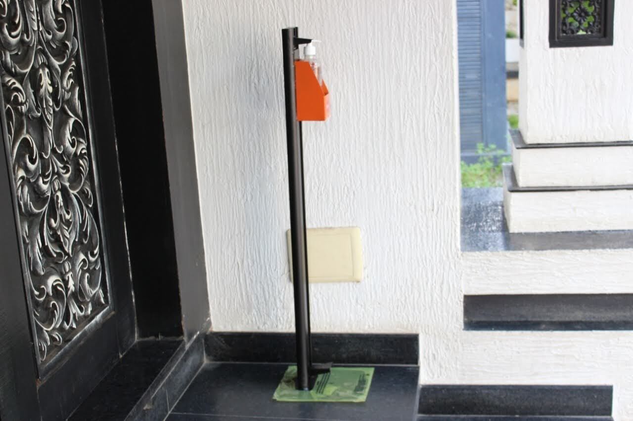A door with intricate metalwork, a black vertical object, and a small orange item on a green mat.