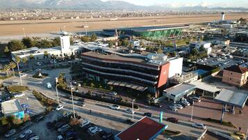 Un terminal aeroportuario con una estructura de estacionamiento de varios niveles, una torre de control y una pista de aterrizaje al fondo.