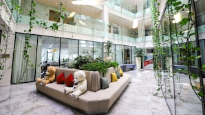 Un intérieur moderne avec un canapé beige, un ours en peluche blanc et des plantes vertes.