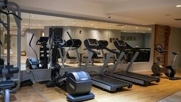 Academia com esteiras, elípticos e equipamentos de musculação.
