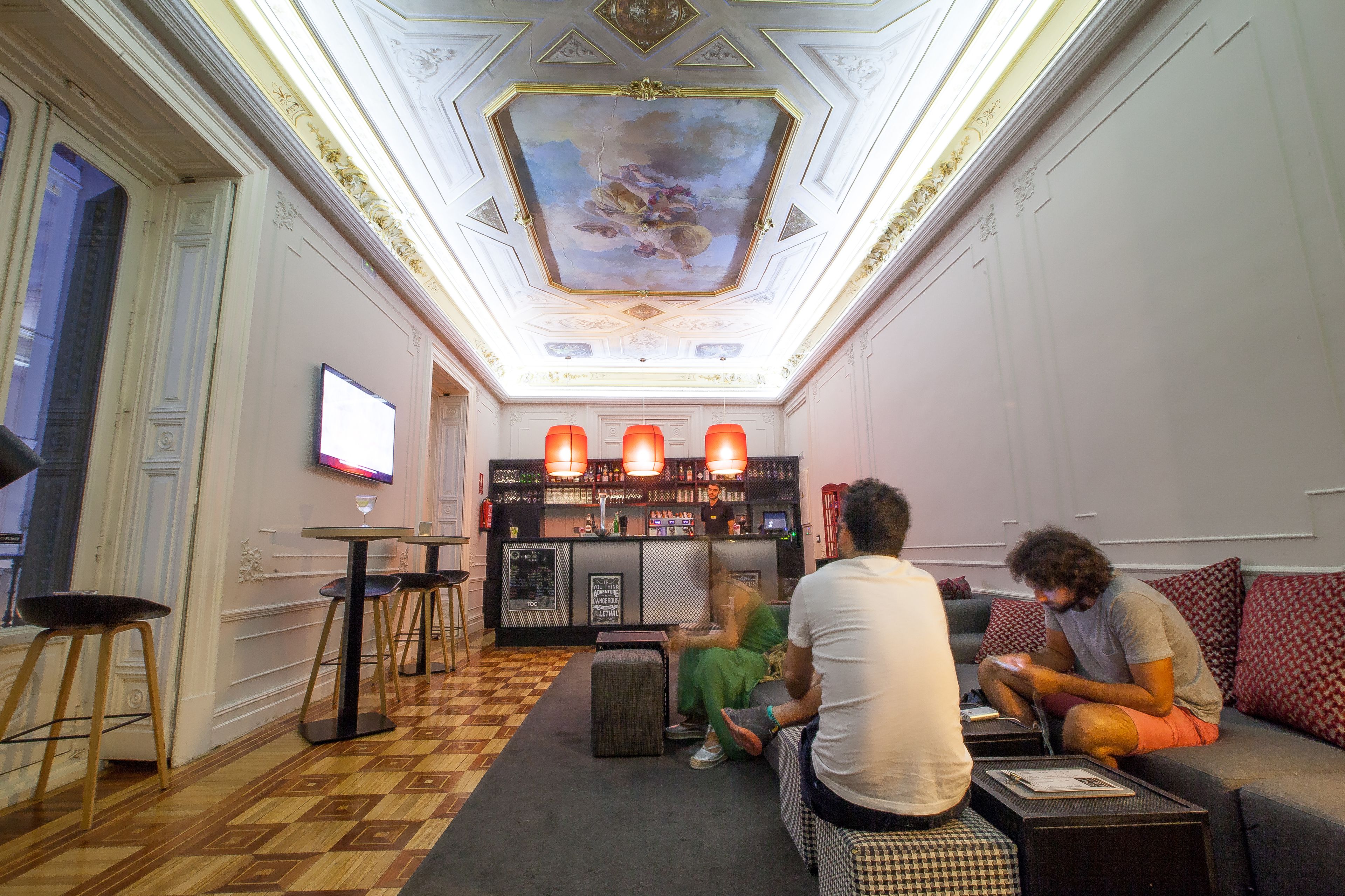 A bar area with a TV, seating, and a bar counter.