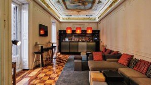 Un lobby lujoso con una zona de bar, un conjunto de sofás y un suelo estampado.
