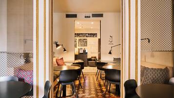 A modern interior with a central seating area, a reception desk, and a wall with a 'Come to Madrid' sign.