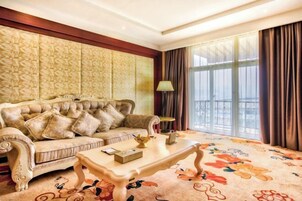 Una habitación con un sofá capitonado, una mesa y una alfombra floral.
