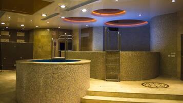 Relax by the mosaic-tiled hot tub, surrounded by a textured mosaic pattern and recessed lighting.