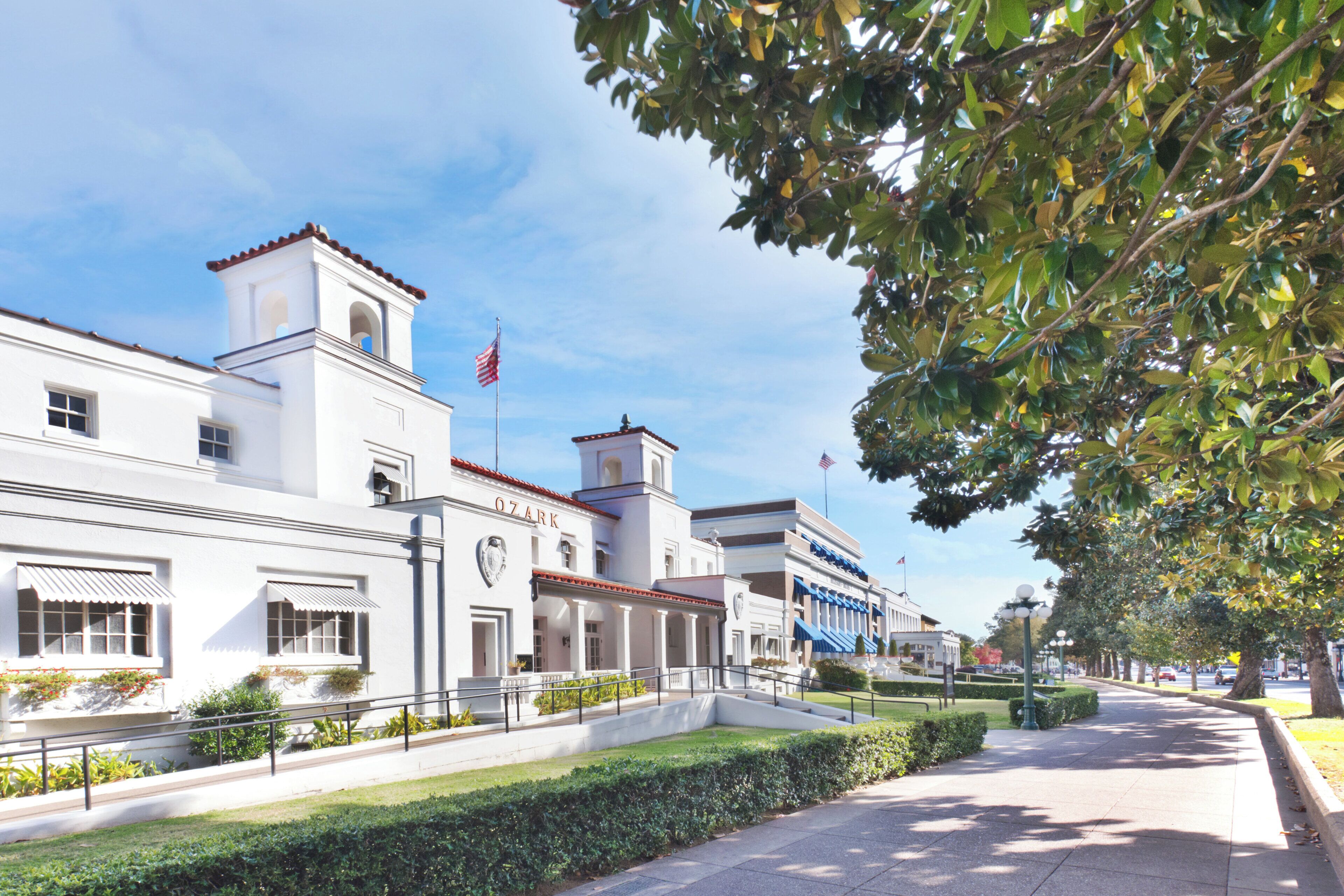 Un edificio con una facciata bianca, una campana e una bandiera americana.