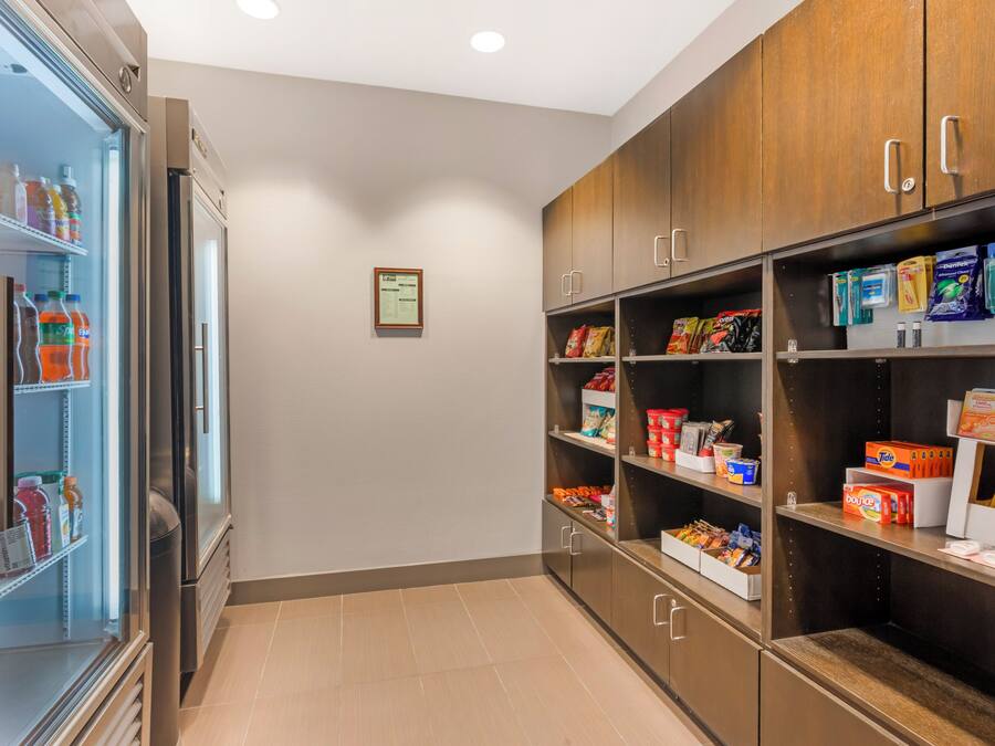 A kitchenette with a refrigerator stocked with beverages, a microwave, and a sink.