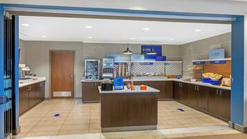 A modern breakfast area with a central island, breakfast bar, and various food stations.