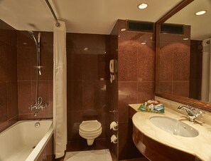 A modern bathroom with a bathtub, a toilet, and a sink. - Club Mahindra White Meadows Manali (Manali)