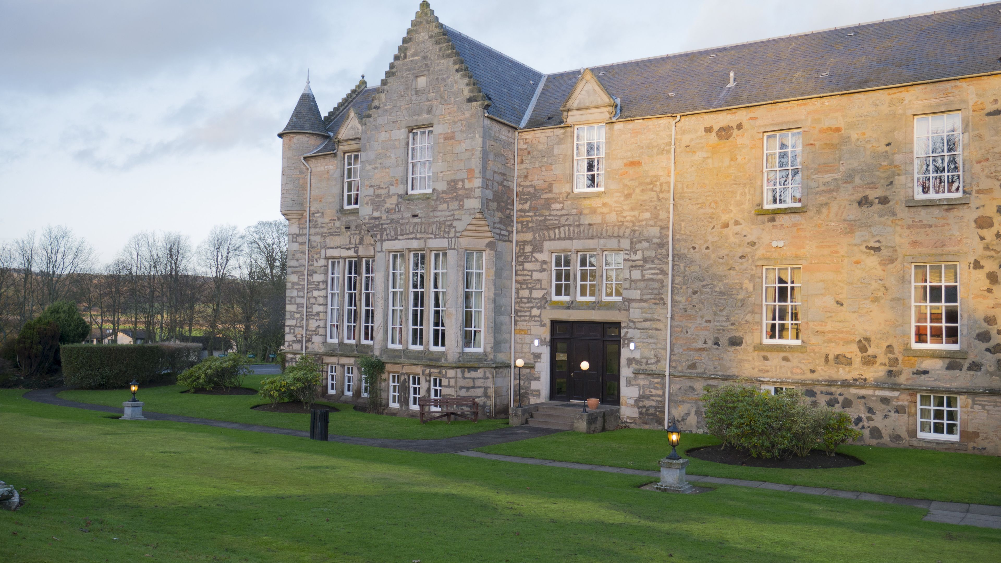 A stone building with multiple windows and a central entrance.