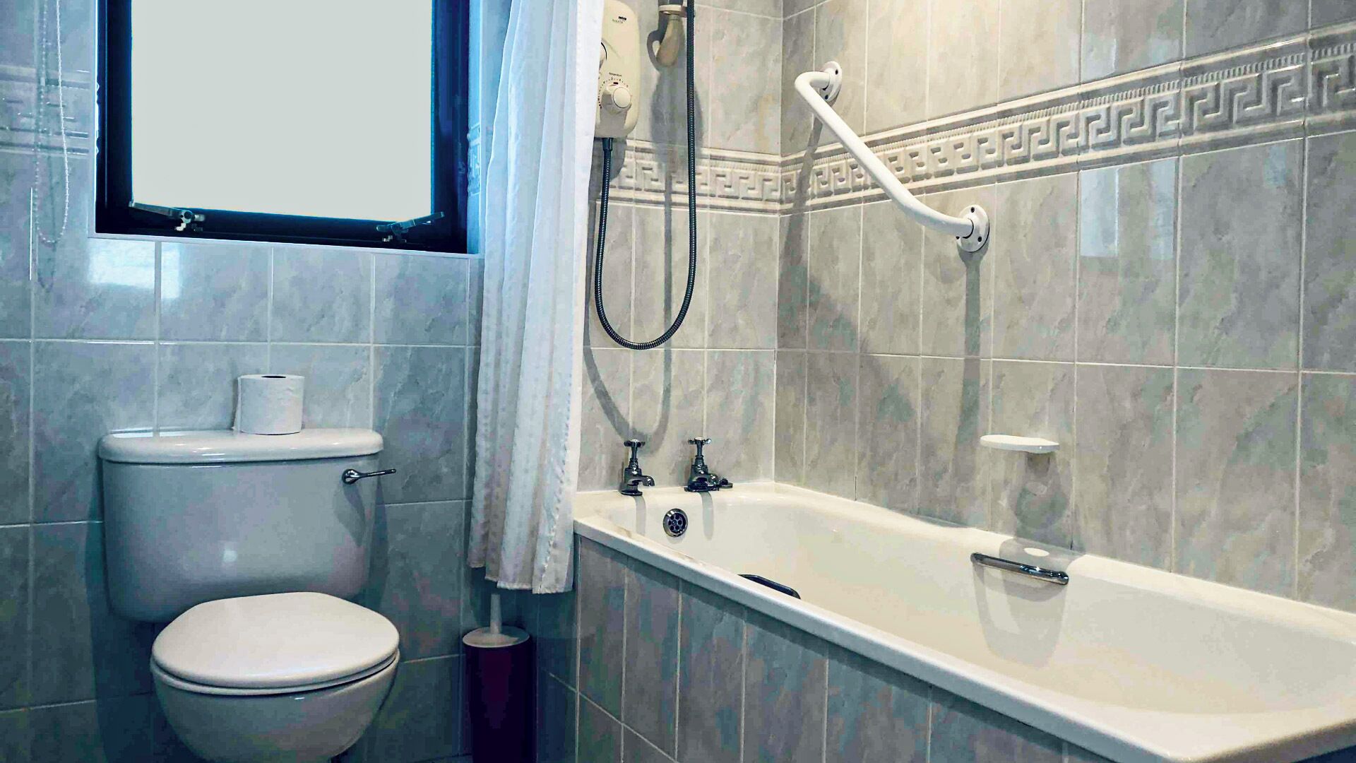 Kylpyhuone, jossa on wc, kylpyamme ja suihku.