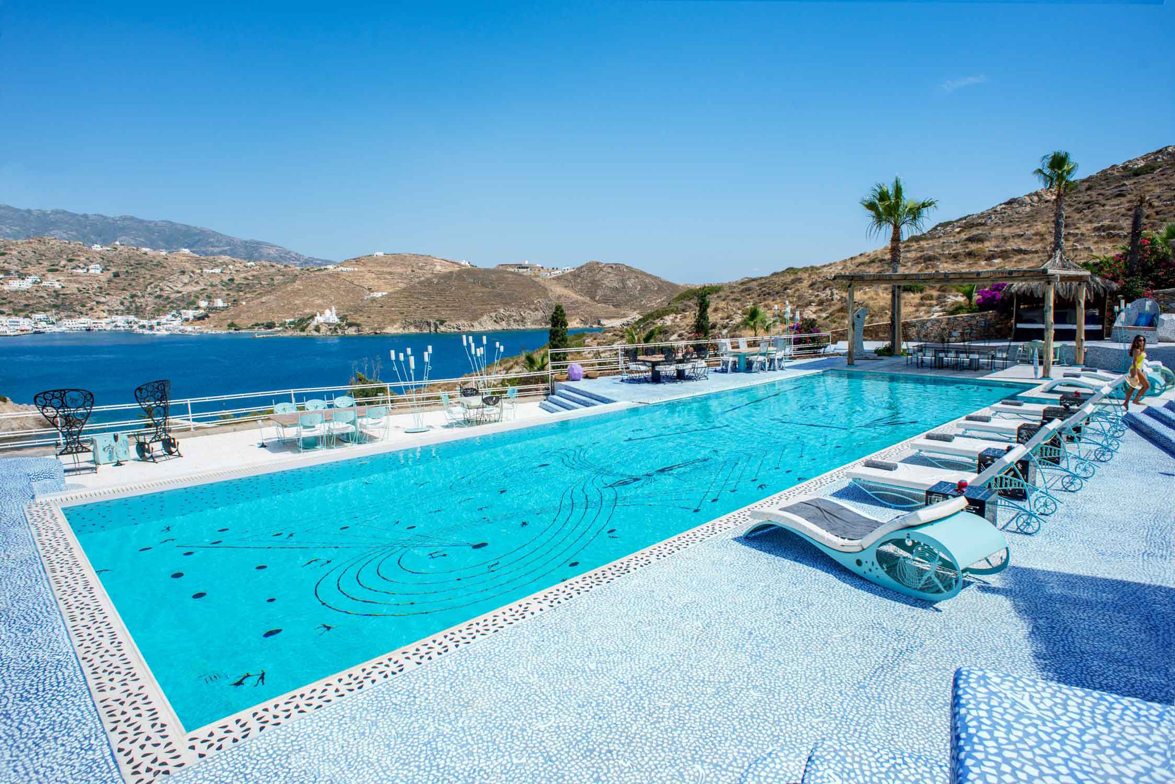 Una piscina amb gandules i vista al mar.