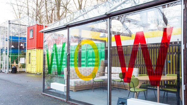 A glass-fronted building with colorful containers and a large 'WOW' sign. - WOW Hostel Amsterdam (Amsterdam)