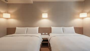 Habitación de hotel con dos camas, cada una con una mesita de noche, una lámpara de pared y un cabecero de madera.