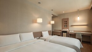 Een hotelkamer met twee bedden, een bureau en een stoel.