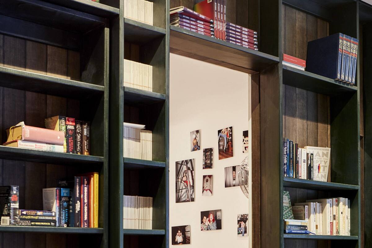 A library with bookshelves on either side of a doorway leading to a bedroom.