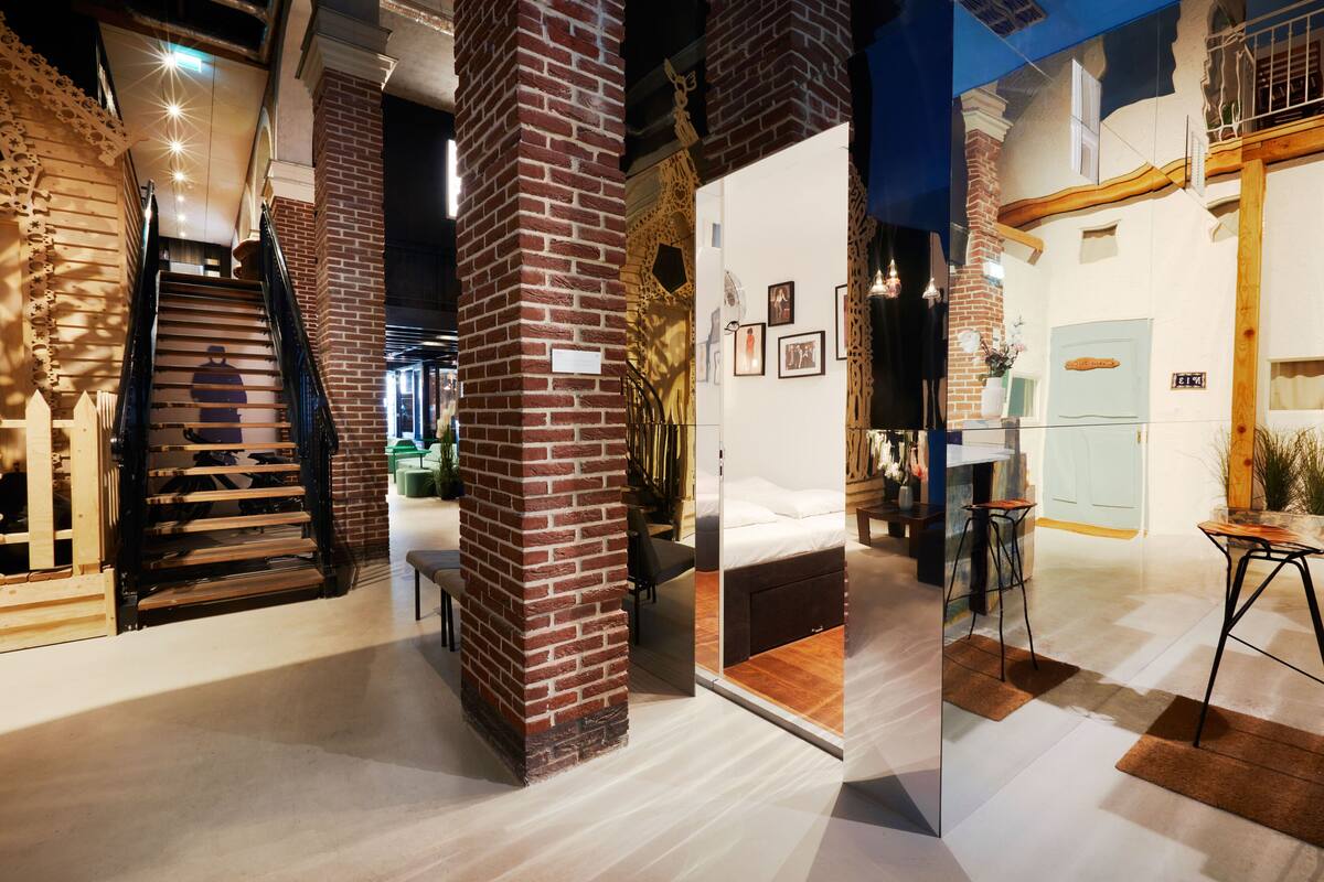 A modern interior with a staircase, a bed, and a dining area.