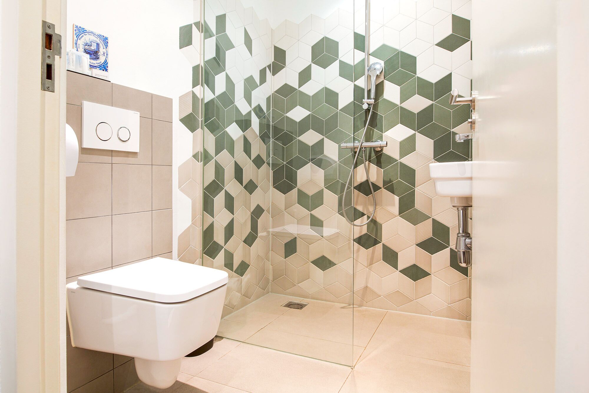 A modern bathroom with a toilet, shower, and sink.