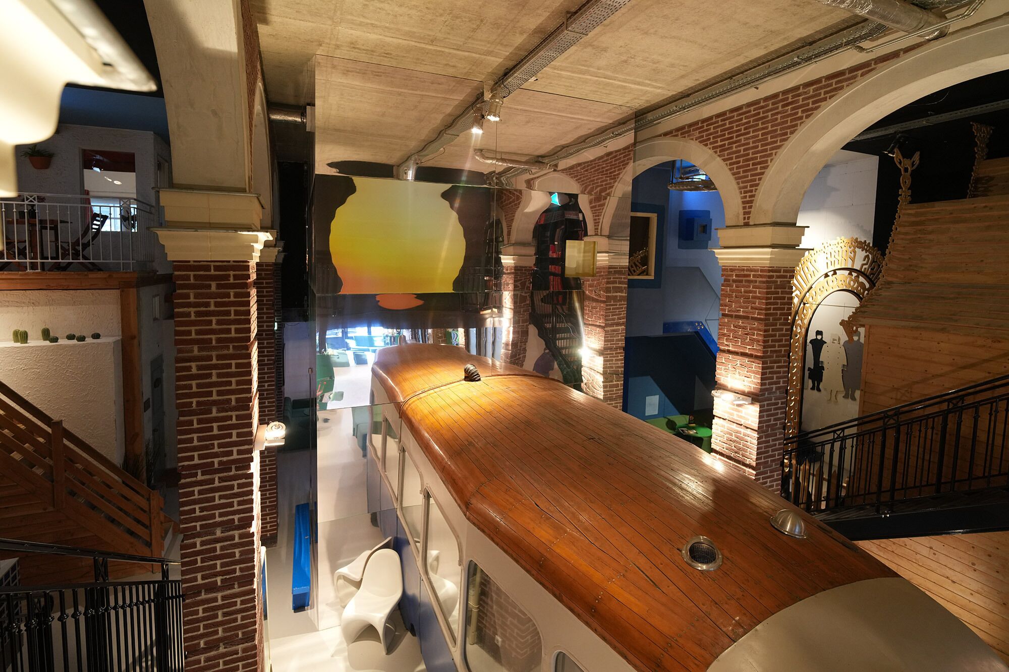 A modern interior with a wooden counter, brick walls, and a staircase.