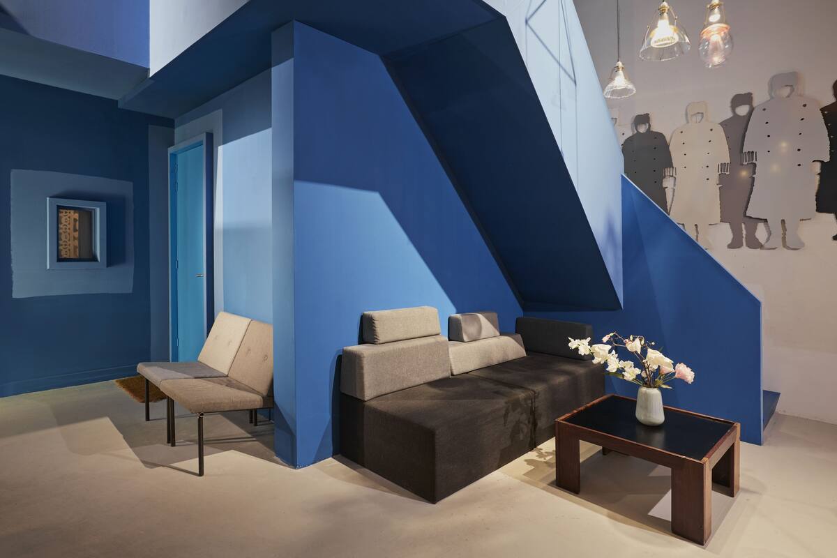 A modern interior with a blue accent wall, a sofa, a chair, and a coffee table.
