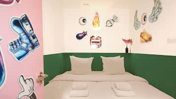 A bedroom with a green headboard, two white pillows, and a bed with white linens.