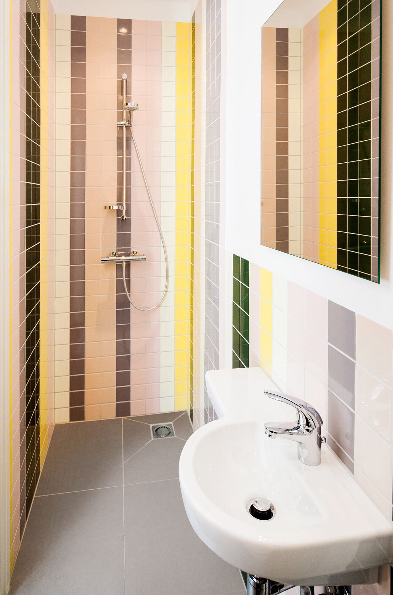 A modern bathroom with a shower, a sink, and a mirror.