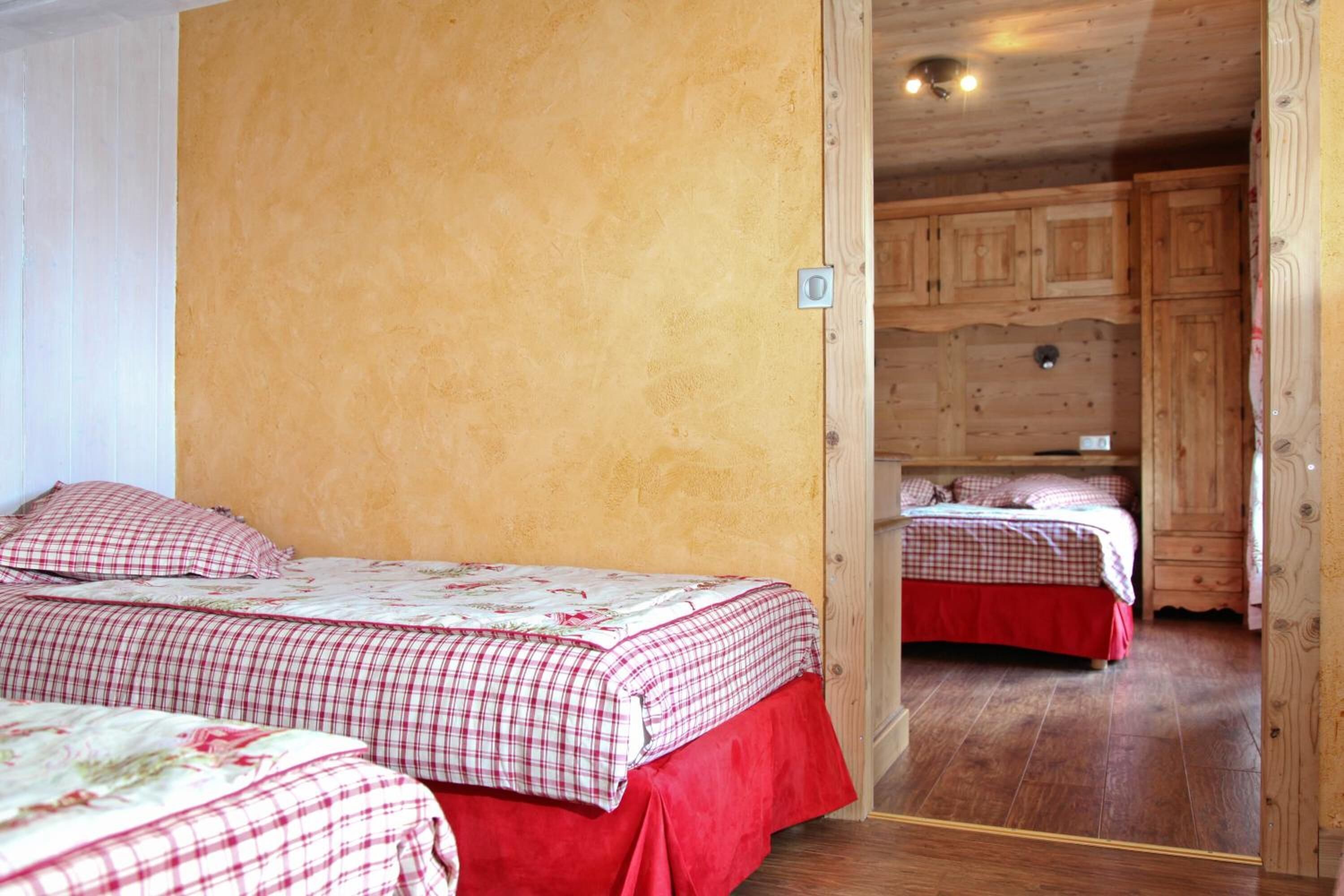 Ein Zimmer mit zwei Betten, Holzwänden und Holzboden.