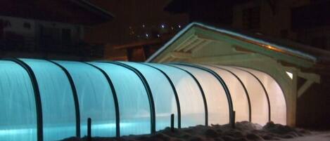 A greenhouse structure with a curved roof and a series of vertical supports.