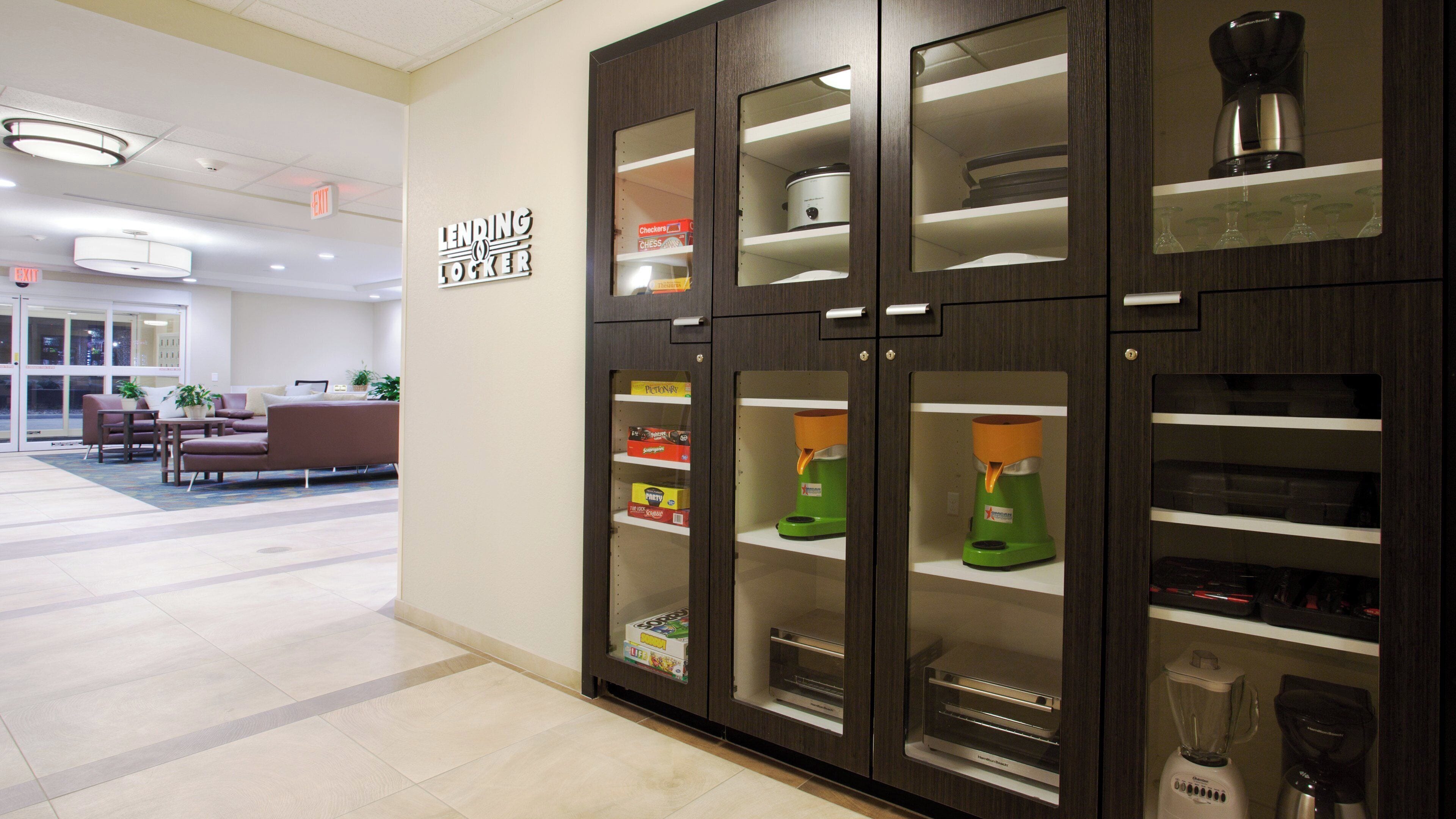 A modern hotel lobby with a lending locker, seating area, and various amenities.