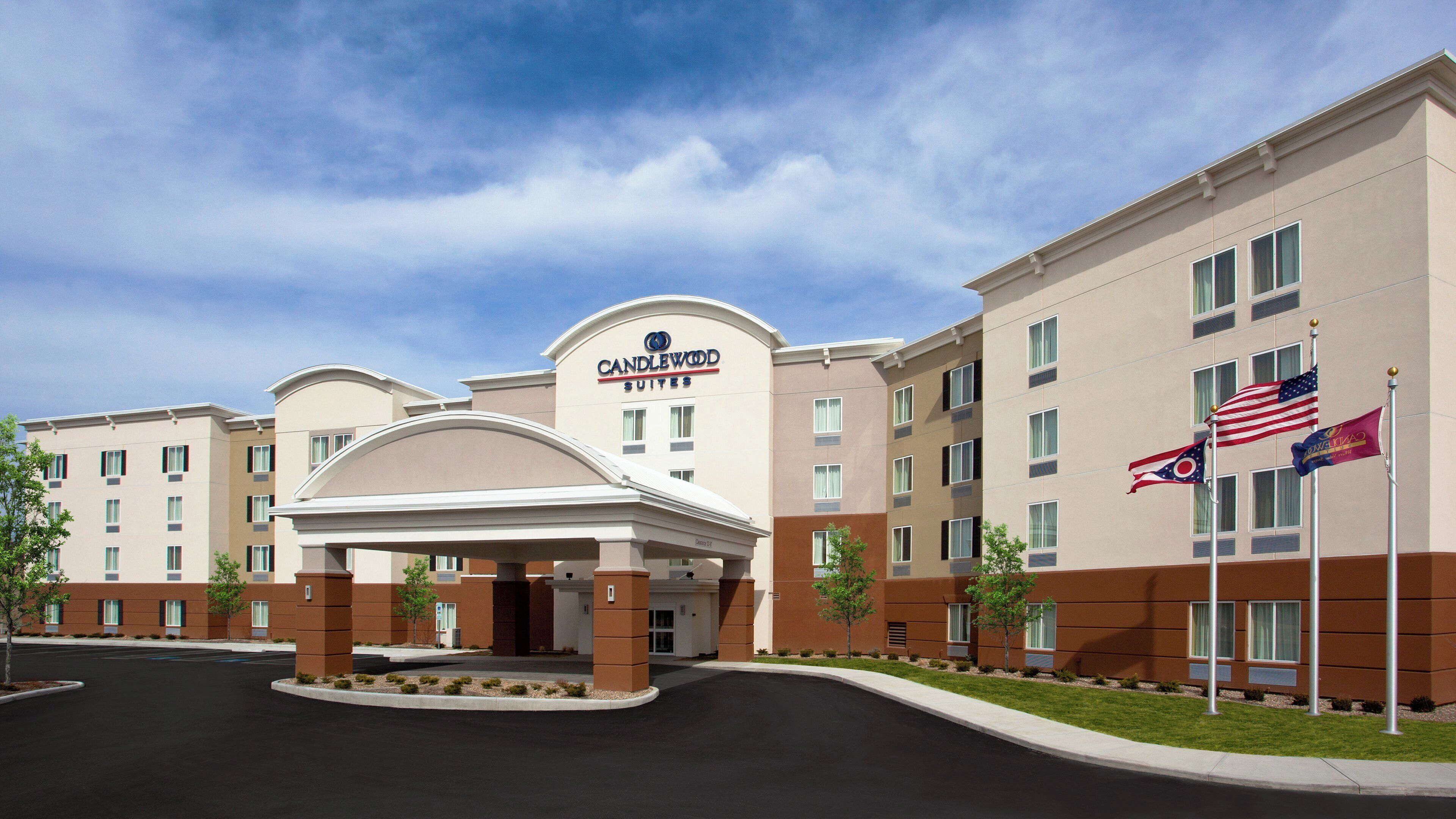 A hotel with a prominent entrance, multiple floors, and flags.
