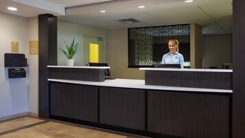 Una recepción con diseño moderno, una planta en maceta y un cartel que indica la propiedad de CPA Carleton ES LLC.