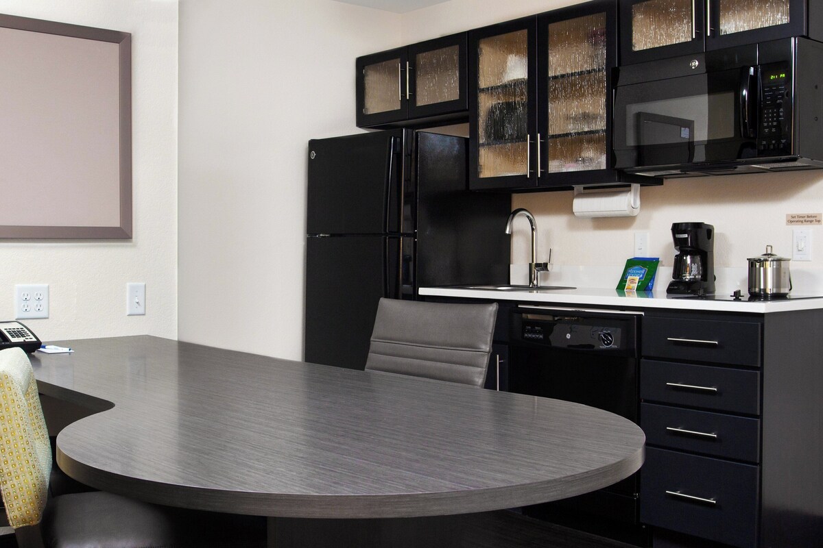 A modern kitchen with a microwave, refrigerator, and coffee maker.