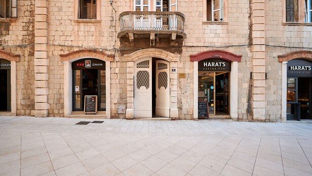 A building with two storefronts, one labeled "IZAKAYA" and the other "HARAT'S Irish Pub". - Marmont City Rooms (Split)