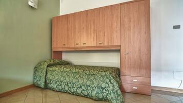 Ein Schlafzimmer mit einem Bett, einem Holzschrank und einer Wandleuchte.
