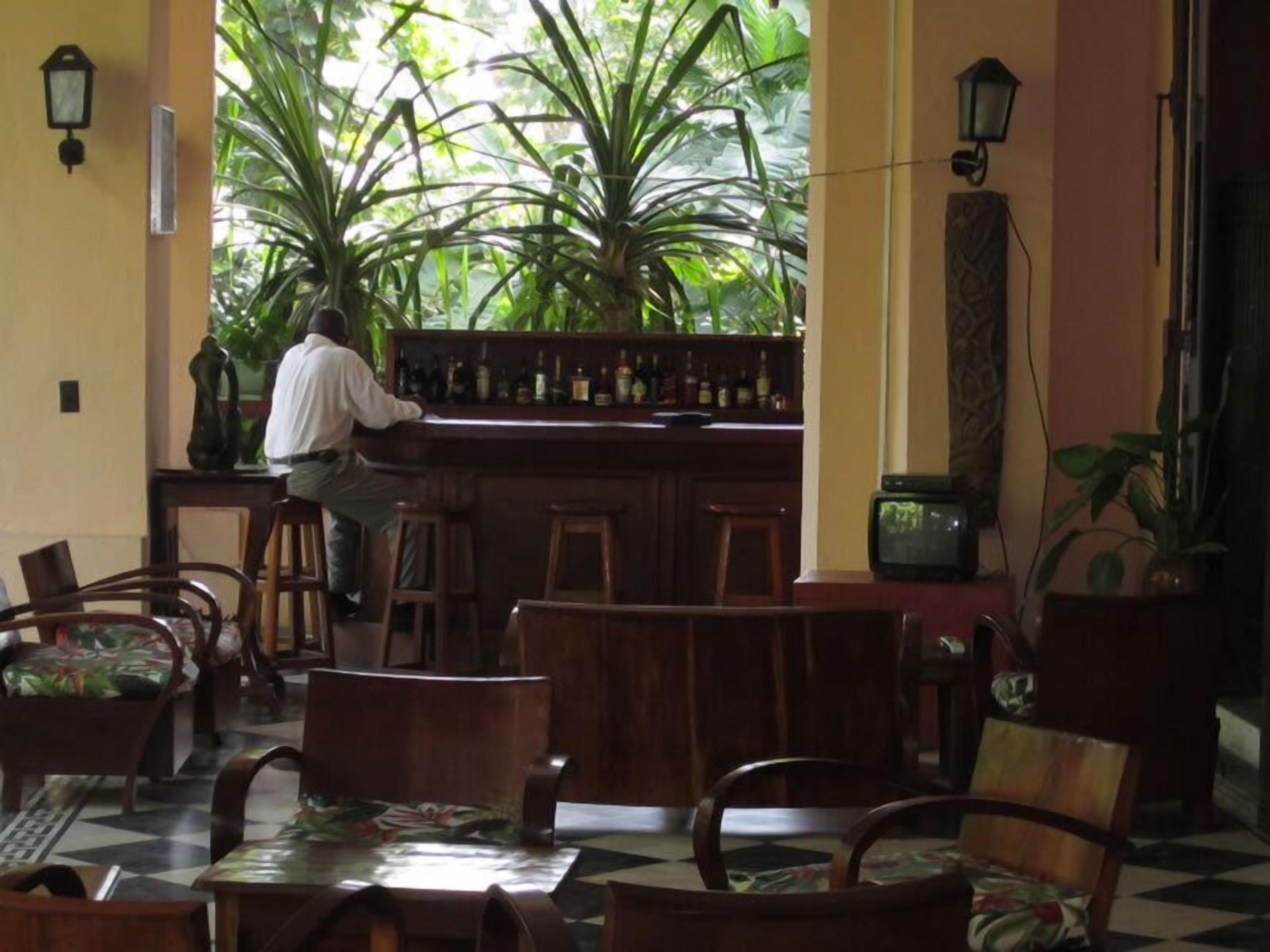 Una zona de bar con muebles de madera y un cantinero.