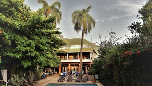A swimming pool with lounge chairs and a building with balconies in the background. - Hôtel du Roi Christophe (Cap-Haitien)
