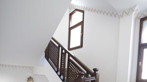 Una escalera con barandas de madera y baldosas de suelo con diseño.